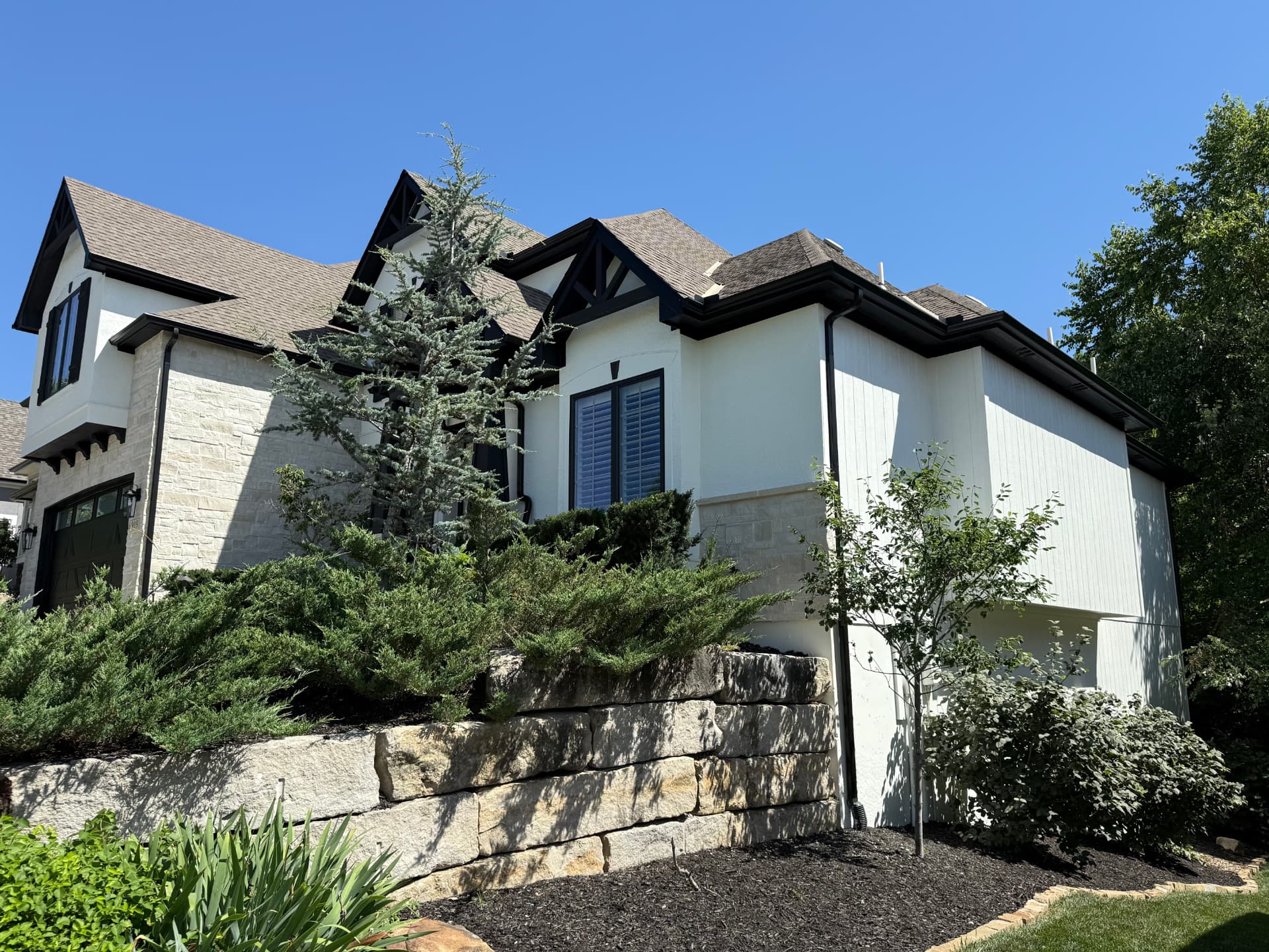 White Tudor-style home exterior with dark stained timber accents painted by All Seasons Painting