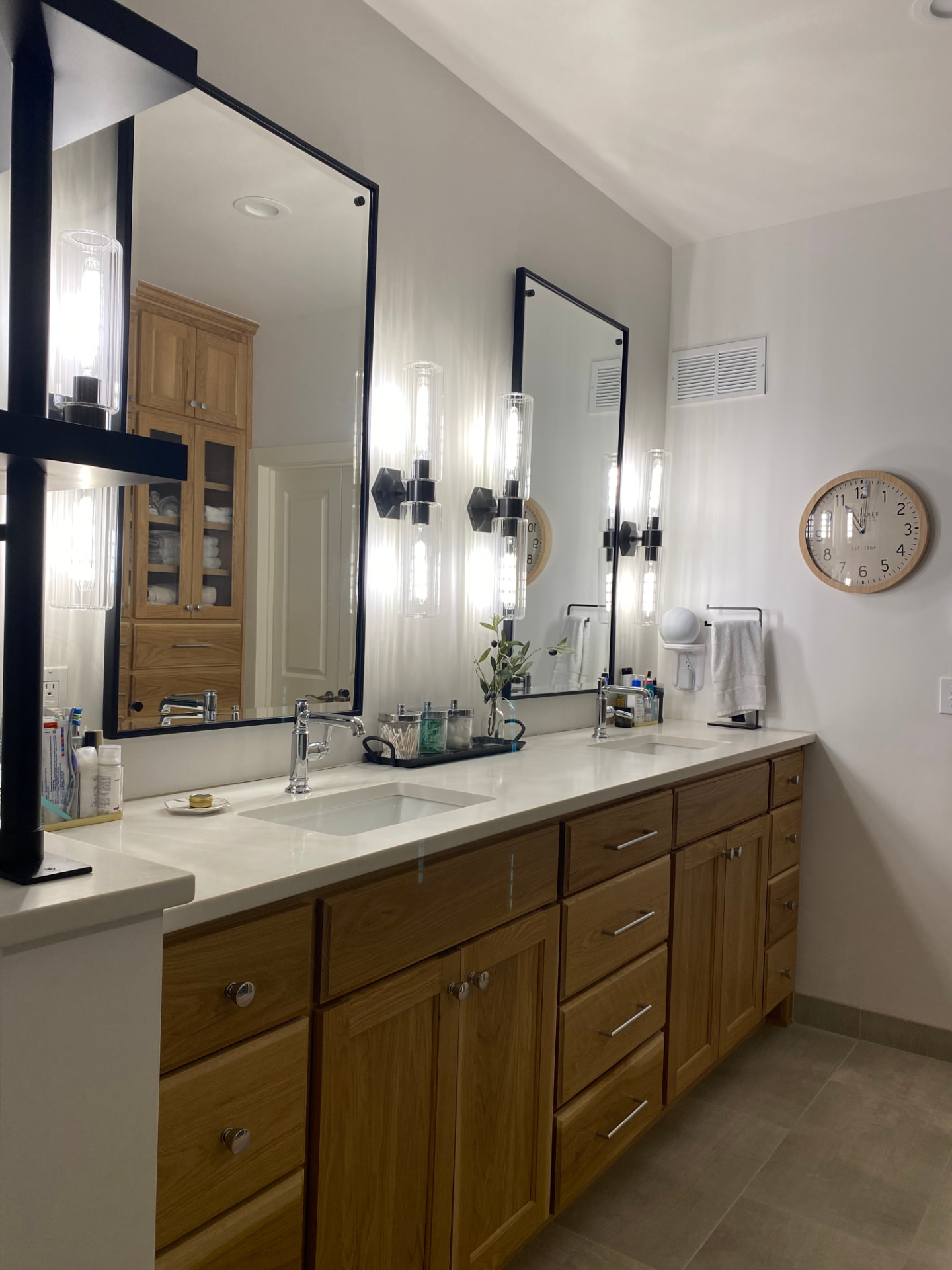 Interior bathroom painting and trim work with double vanity, mirrors, and modern lighting