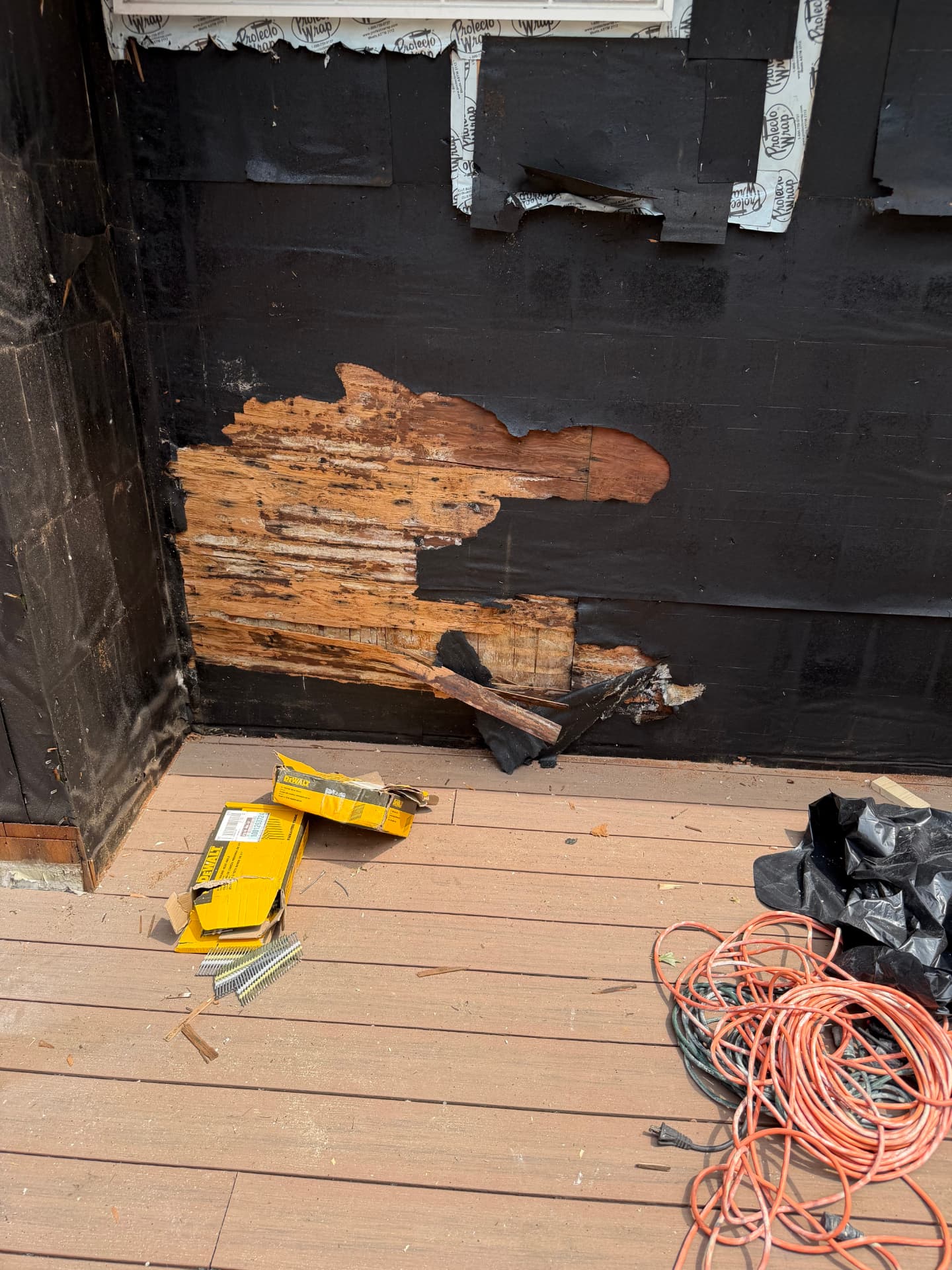 Rotted wood sheathing exposed behind siding on a Kansas City home during wood rot repair