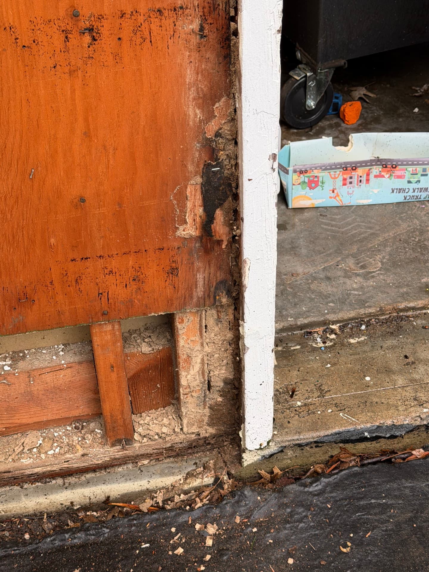 Rotted garage door jamb and framing at the slab where water sat against the wood