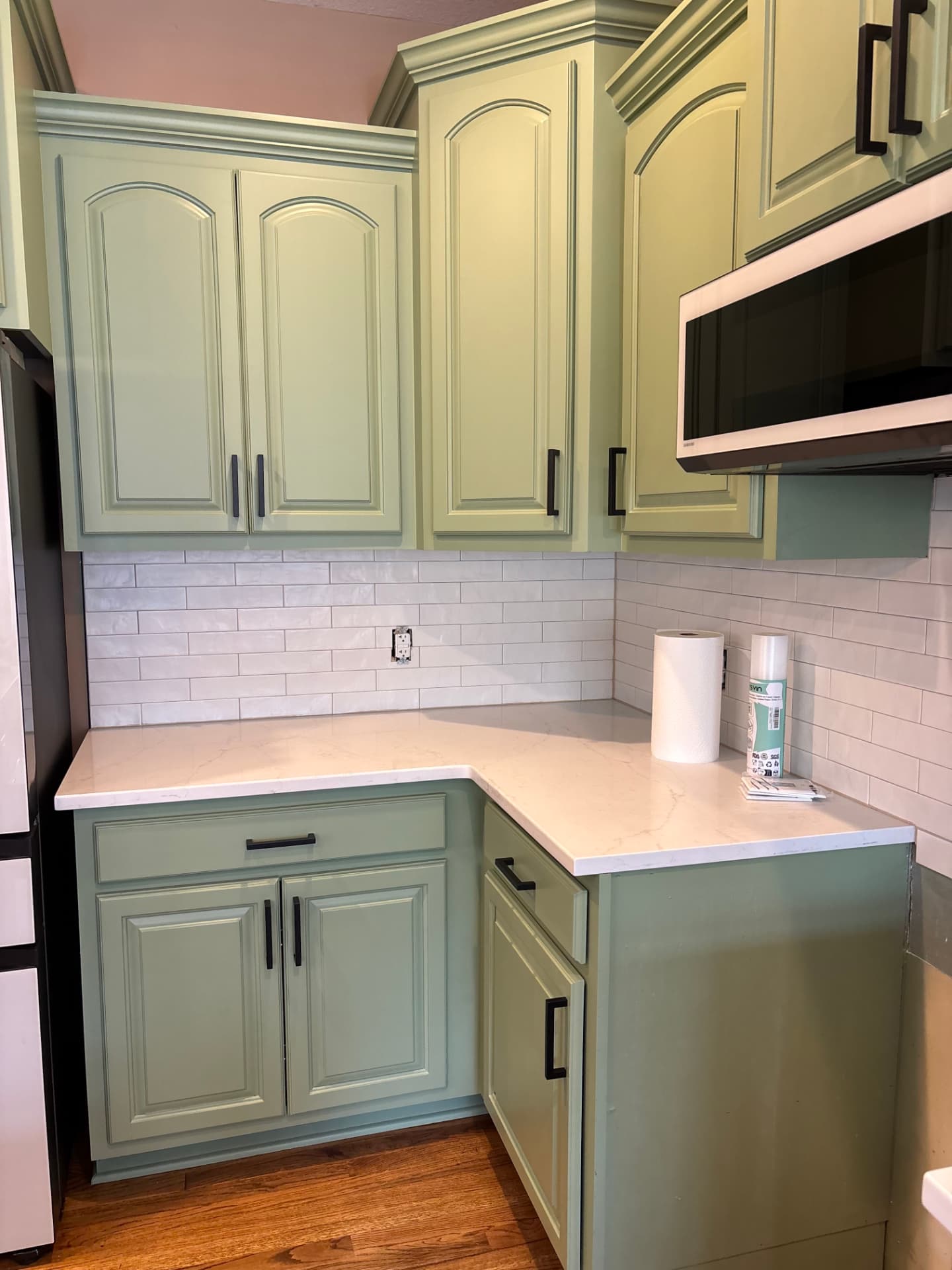 Sage green cabinet uppers and lowers with a durable smooth finish